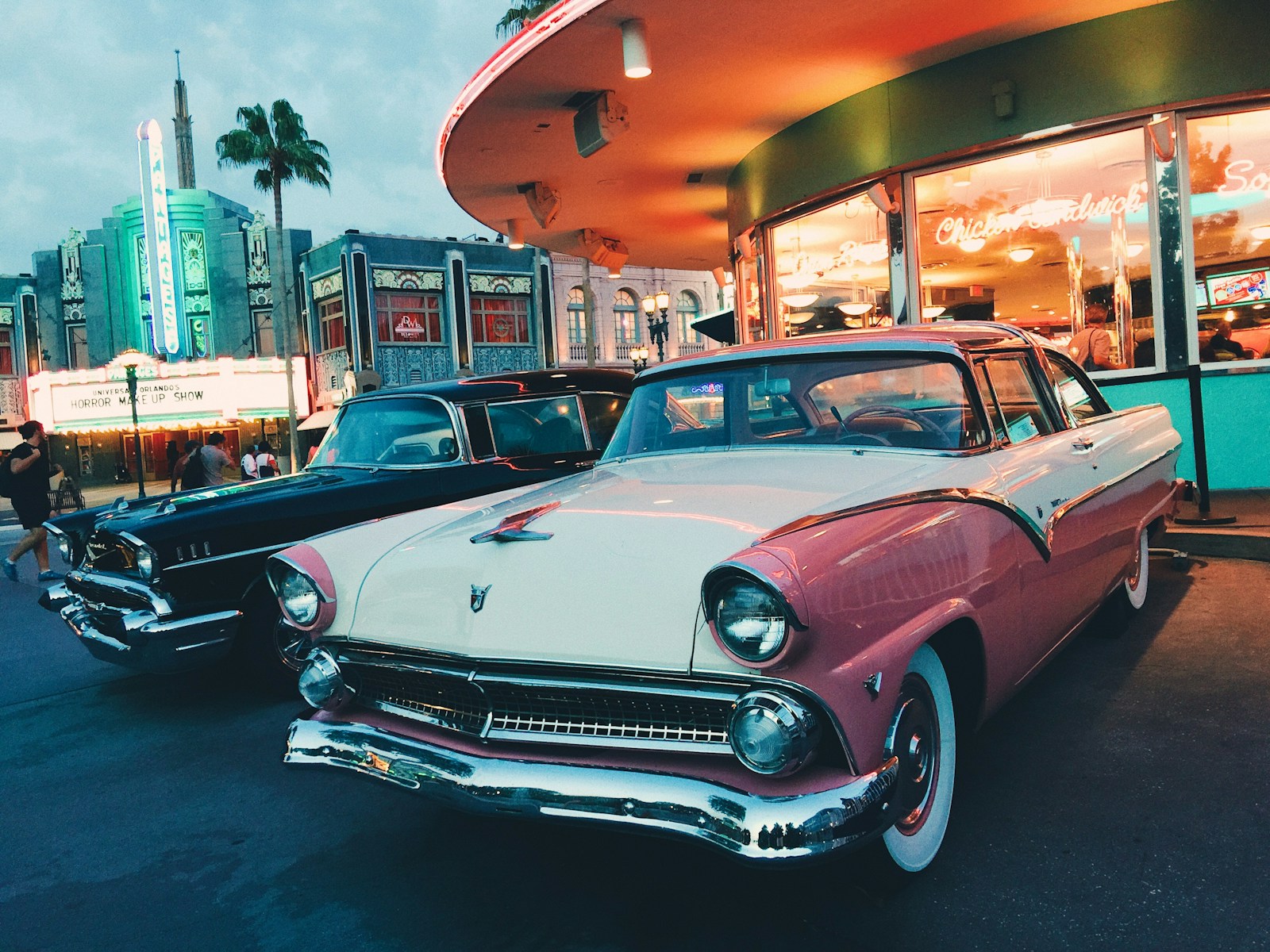 white and pink coupe parked beside black car, auto